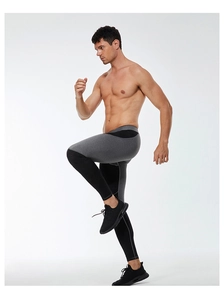 Action shot of men's compression tights showing flexible grey and black patchwork fabric