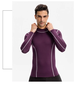 Détail du t-shirt de compression violet foncé montrant les coutures grises et le tissu sport