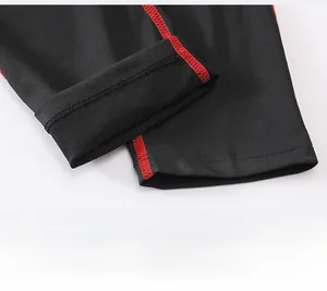 Detail of boys compression pants showing black fabric with red flatlock stitching
