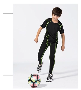 Kids quick-dry sports set with green stitching, showing flexible fit during soccer play
