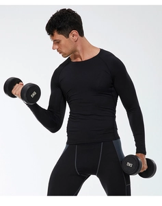 Studio shot of men's quick-dry black compression shirt and pants set with dumbbells