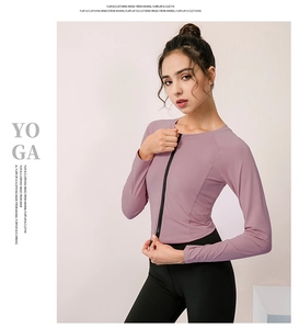 Dettaglio del tessuto a maglia elastica e della cerniera sulla maglia da yoga viola a maniche