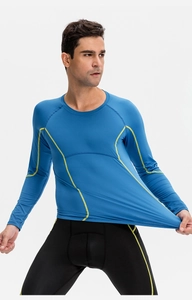 Detail of blue men's compression shirt showing high-elasticity fabric with yellow stitching