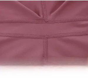 Détail du legging de yoga montrant les coutures lisses et le tissu en maille rose