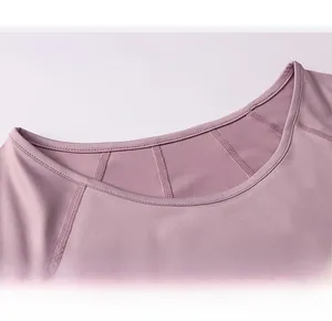 Dettaglio del classico scollo rotondo su una t-shirt fitness rosa elastica per donna