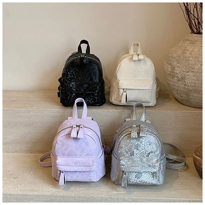 Mini backpacks in black, white, purple and silver with snakeskin texture on stone steps