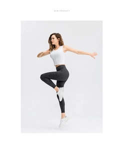 Detailaufnahme der weißen Fitnessweste mit Reißverschluss und Marmor-Sportleggings