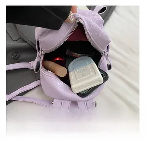 Detail showing the internal storage capacity of the purple crocodile texture mini backpack