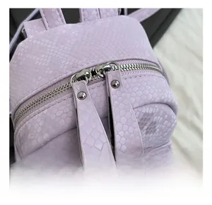 Detail of silver dual zippers on light purple faux snake skin textured backpack