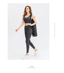 Detail of high-waist yoga leggings featuring a dark grey marble print and sporty tank top