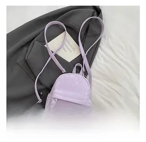 Detail showing lavender faux leather backpack with refined snakeskin texture and silver zippers