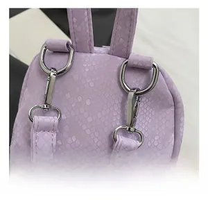 Macro shot of high-quality silver metal hooks and lavender snakeskin texture on backpack