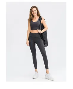 Full body shot of woman in dark gray marble printed high waist yoga pants and sports bra