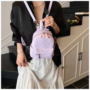 Detail of light purple mini backpack with snakeskin pattern and dual metal zippers