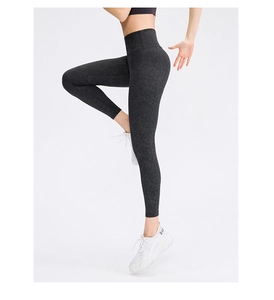 Detailed side view of high-waisted black marble printed yoga leggings on model