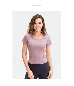 Dettaglio del top da yoga rosa traspirante con maniche raglan atletiche da donna