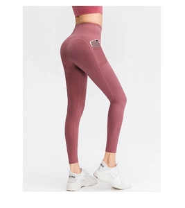 Détail d'un legging de yoga taille haute avec poches latérales en rose poudré