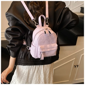 Rear view of a model wearing a mini lavender snake-pattern backpack with silver zippers