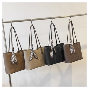 Close-up of four lychee leather tote bags in brown, beige, black, and coffee with scarves