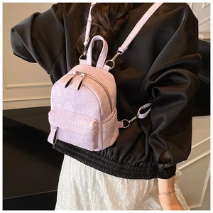 Detail view of light purple mini backpack with snakeskin texture and adjustable straps