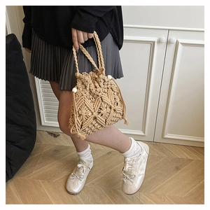 Detail of bohemian crochet bucket bag with wooden beads and woven shoulder strap
