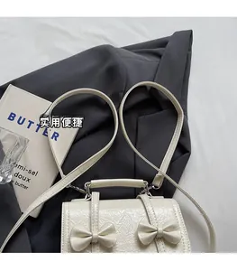 Off-white pleated leather bag detail featuring two 3D bows and adjustable strap