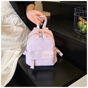 Detail of lavender faux snakeskin texture and zipper pockets on the stylish backpack