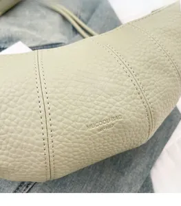 Detailed macro view of lychee pattern leather and stitching on the croissant bag
