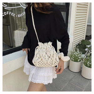 Detail of bohemian macrame bucket bag with hollow diamond pattern and drawstring