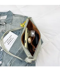 Spacious interior of a green leather crescent bag with phone and cosmetics layout