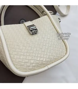 Détail du sac à main tressé blanc montrant la texture et le fermoir en métal argenté