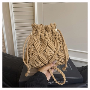 Detail of hand-woven straw bucket bag with khaki geometric patterns and drawstring beads