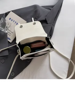 Spacious interior of white pleated crossbody bag with magnetic clasp and slim strap