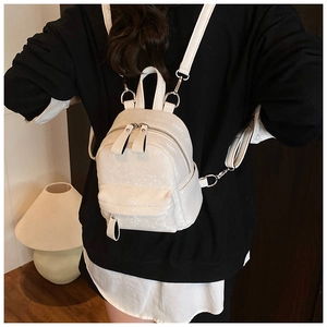 Detailed view of mini faux python skin backpack in beige showing texture and straps