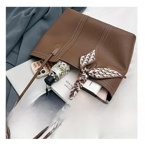 Brown lychee leather tote bag showing large capacity for tablet, umbrella and books