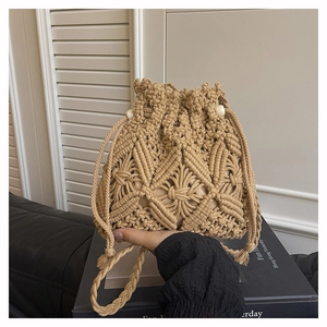 Close-up of beige crochet bucket bag featuring intricate diamond-weave and white beads