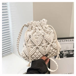 Detailed macro view of the cream handmade macrame woven bucket bag and drawstring closure