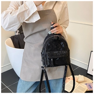 Detailed view of the mini black backpack featuring textured snakeskin pattern on PU leather