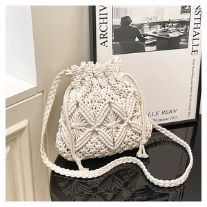 Detailed close-up of handmade cream macrame bucket bag with geometric crochet patterns