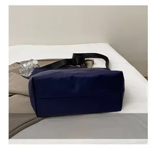 Detail shot showing the wear-resistant base of the large dark blue nylon tote bag
