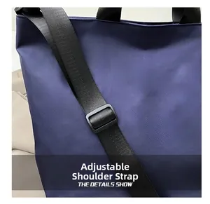 Detail view of the adjustable wide nylon shoulder strap on the navy blue tote bag