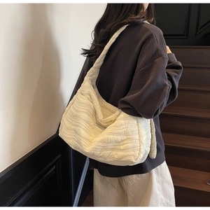 Detail of off-white quilted tote bag with wavy stitching and large capacity design
