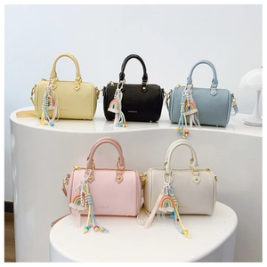 Detail view of multi-color boston bags with lychee texture and rainbow tassel pendants