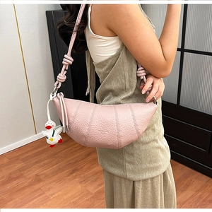 Detail of light pink croissant shoulder bag with pleated leather and knotted strap