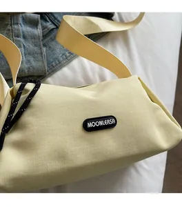 Détail de la texture en toile jaune pâle avec logo en caoutchouc et cordon décoratif