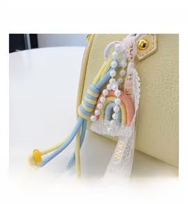 Detail of colorful rainbow charm with pearls on yellow lychee texture leather handbag