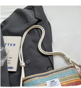 Detail of colorful striped woven bucket bag with rope handles and minimal logo patch