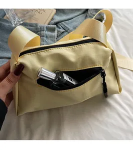 Détail du sac bandoulière jaune présentant une poche de rangement zippée pratique au dos