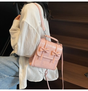 Pink glossy patent leather backpack with twin bows and adjustable shoulder strap