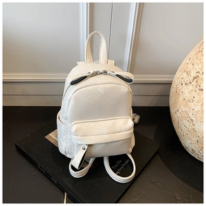 Detail shot of the white snake pattern mini backpack showing texture and front pocket